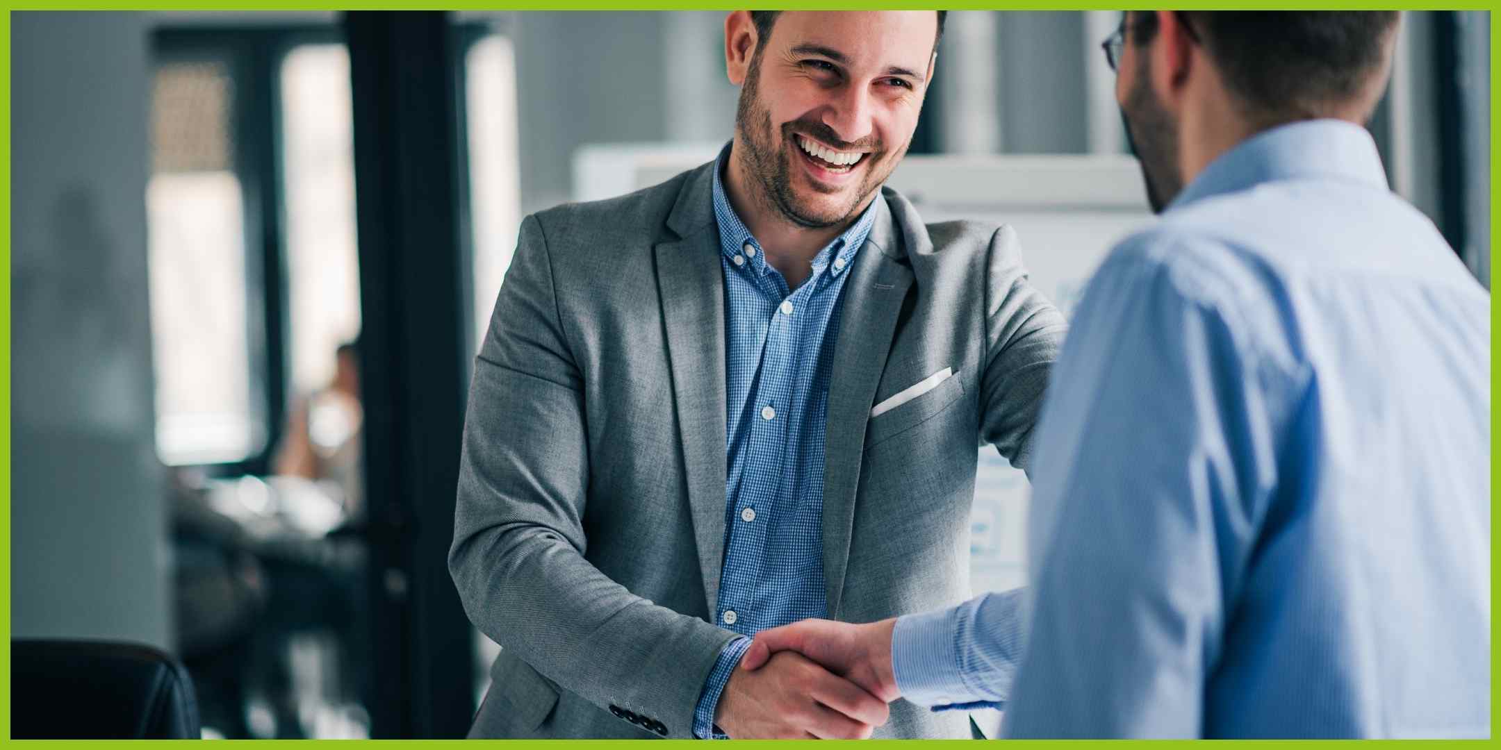 Two smiling men shaking hands